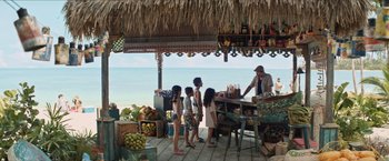 Movie still from “In the Heights” (2021), directed by Jon M. Chu – A group of people standing in front of a table; Wide shot, Over the shoulder angle