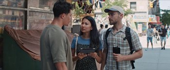 Movie still from “In the Heights” (2021), directed by Jon M. Chu – A group of people standing next to each other on the street; Medium shot, Over the shoulder angle