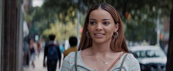Movie still from “In the Heights” (2021), directed by Jon M. Chu – A young woman with long brown hair wearing a necklace; Close Up shot, Over the shoulder angle