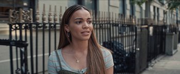 Movie still from “In the Heights” (2021), directed by Jon M. Chu – A woman with long brown hair wearing a striped shirt; Close Up shot, Over the shoulder angle