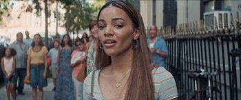 Movie still from “In the Heights” (2021), directed by Jon M. Chu – A person with long brown hair; Close Up shot, Over the shoulder angle