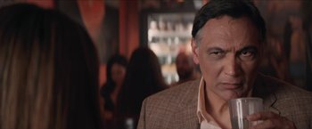 Movie still from “In the Heights” (2021), directed by Jon M. Chu – A person wearing a suit and tie; Close Up shot, Over the shoulder angle