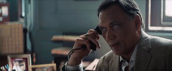 Movie still from “In the Heights” (2021), directed by Jon M. Chu – A man talking on a cell phone while wearing a ring on his finger; Close Up shot, Low angle