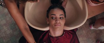 Movie still from “In the Heights” (2021), directed by Jon M. Chu – A woman getting her hair washed at a hair salon; Close Up shot, Over the shoulder angle