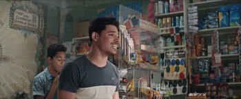 A man standing next to a store filled with lots of items