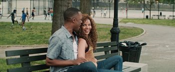 Movie still from “In the Heights” (2021), directed by Jon M. Chu – A man and a woman sitting on a park bench; Medium shot, Over the shoulder angle