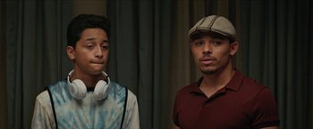 Movie still from “In the Heights” (2021), directed by Jon M. Chu – Two young men standing next to each other in a room; Close Up shot, Over the shoulder angle