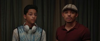 Movie still from “In the Heights” (2021), directed by Jon M. Chu – Two young men are posing for a picture; Close Up shot, Over the shoulder angle