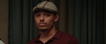 Movie still from “In the Heights” (2021), directed by Jon M. Chu – A person wearing a hat; Close Up shot, Over the shoulder angle
