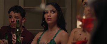 Movie still from “In the Heights” (2021), directed by Jon M. Chu – A beautiful young lady in a green top and gold hoop earrings; Close Up shot, Over the shoulder angle