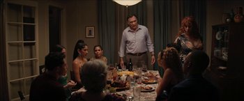 Movie still from “In the Heights” (2021), directed by Jon M. Chu – A group of people sitting around a dinner table; Medium shot, Over the shoulder angle