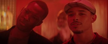 Movie still from “In the Heights” (2021), directed by Jon M. Chu – A group of men standing next to each other in a room; Close Up shot, Over the shoulder angle