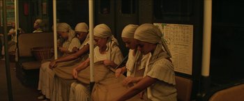 Movie still from “In the Heights” (2021), directed by Jon M. Chu – A group of women in a room working on a project; Wide shot, High angle