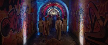 Movie still from “In the Heights” (2021), directed by Jon M. Chu – A group of people walking down a tunnel; Wide shot, High angle