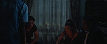 A man and a woman sitting in front of a window at night