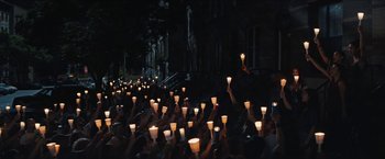 Movie still from “In the Heights” (2021), directed by Jon M. Chu – A group of people holding lit candles in the dark; Extreme Wide shot, High angle