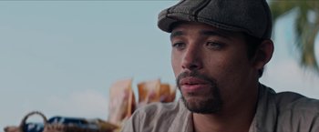 Movie still from “In the Heights” (2021), directed by Jon M. Chu – A person wearing a hat; Close Up shot, Over the shoulder angle