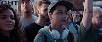 Movie still from “In the Heights” (2021), directed by Jon M. Chu – A young man wearing headphones and a hat; Close Up shot, Low angle