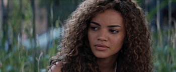 Movie still from “In the Heights” (2021), directed by Jon M. Chu – A person with curly hair; Close Up shot, Over the shoulder angle