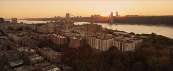 Movie still from “In the Heights” (2021), directed by Jon M. Chu – An aerial view of a city with a bridge in the background; Extreme Wide shot, High angle
