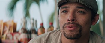 Movie still from “In the Heights” (2021), directed by Jon M. Chu – A man with a hat on; Close Up shot, Over the shoulder angle