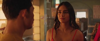 Movie still from “In the Heights” (2021), directed by Jon M. Chu – A woman in a red top looking at a man in a red shirt; Close Up shot, Over the shoulder angle