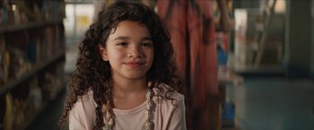 Movie still from “In the Heights” (2021), directed by Jon M. Chu – A little girl with curly hair and a pink shirt; Close Up shot, Over the shoulder angle