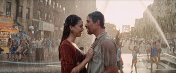 Movie still from “In the Heights” (2021), directed by Jon M. Chu – A man and a woman standing next to each other in the rain; Medium shot, Over the shoulder angle