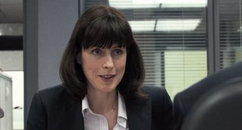 Movie still from “In the Loop” (2009), directed by Armando Iannucci – A person wearing a suit and tie; Close Up shot, Over the shoulder angle
