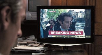 Movie still from “In the Loop” (2009), directed by Armando Iannucci – A television screen showing a news story about a man being murdered; Extreme Close Up shot, Over the shoulder angle