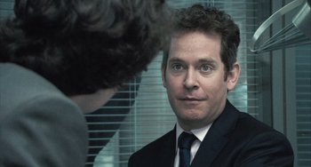 Movie still from “In the Loop” (2009), directed by Armando Iannucci – A man in a suit and tie looking at a man in a tie; Close Up shot, Over the shoulder angle
