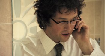 Movie still from “In the Loop” (2009), directed by Armando Iannucci – A person talking on a cell phone; Close Up shot, Over the shoulder angle