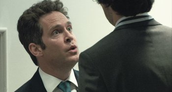 Movie still from “In the Loop” (2009), directed by Armando Iannucci – A man in a suit and tie talking to another man in a suit and tie; Close Up shot, Over the shoulder angle