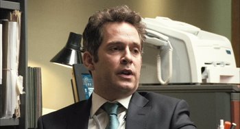 Movie still from “In the Loop” (2009), directed by Armando Iannucci – A person wearing a suit and a tie; Close Up shot, Over the shoulder angle