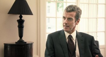 Movie still from “In the Loop” (2009), directed by Armando Iannucci – A person wearing a suit and tie; Close Up shot, Over the shoulder angle