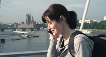 Movie still from “In the Loop” (2009), directed by Armando Iannucci – A woman talking on a cell phone near a body of water; Close Up shot, Over the shoulder angle