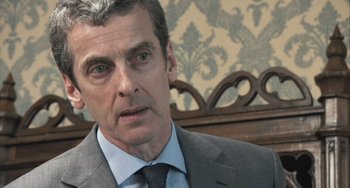 Movie still from “In the Loop” (2009), directed by Armando Iannucci – A person wearing a suit and tie; Close Up shot, Over the shoulder angle