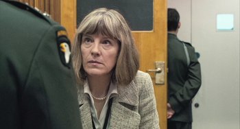 Movie still from “In the Loop” (2009), directed by Armando Iannucci – A woman wearing a suit and looking to her left; Close Up shot, Over the shoulder angle