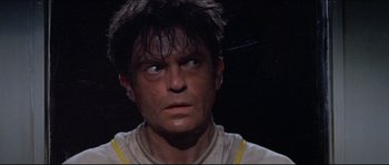Movie still from “In the Mouth of Madness” (1994), directed by John Carpenter – A person with wet hair looking at the camera; Close Up shot, Low angle