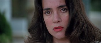 Movie still from “In the Mouth of Madness” (1994), directed by John Carpenter – A woman's eyes and face; Close Up shot, High angle