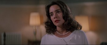 Movie still from “In the Mouth of Madness” (1994), directed by John Carpenter – A person wearing a necklace; Close Up shot, Low angle