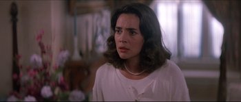 Movie still from “In the Mouth of Madness” (1994), directed by John Carpenter – A person wearing a white shirt; Close Up shot, Over the shoulder angle