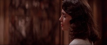 Movie still from “In the Mouth of Madness” (1994), directed by John Carpenter – A person wearing a white shirt; Close Up shot, Over the shoulder angle