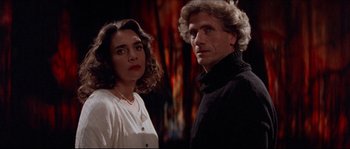 Movie still from “In the Mouth of Madness” (1994), directed by John Carpenter – A man and a woman standing next to each other; Close Up shot, Low angle