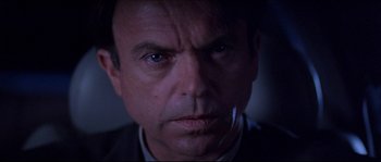 Movie still from “In the Mouth of Madness” (1994), directed by John Carpenter – A man's face in the dark; Close Up shot, Low angle