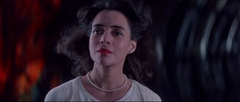 Movie still from “In the Mouth of Madness” (1994), directed by John Carpenter – A person wearing a necklace; Close Up shot, Low angle