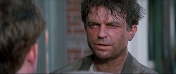 Movie still from “In the Mouth of Madness” (1994), directed by John Carpenter – A person with wet hair; Close Up shot, Over the shoulder angle