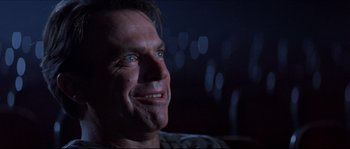 Movie still from “In the Mouth of Madness” (1994), directed by John Carpenter – A person smiling; Close Up shot, Low angle
