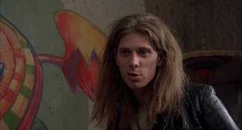 Movie still from “In the Name of the Father” (1993), directed by Jim Sheridan – A man with long hair and a leather jacket; Close Up shot, Over the shoulder angle