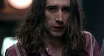 Movie still from “In the Name of the Father” (1993), directed by Jim Sheridan – A person with long brown hair; Close Up shot, Over the shoulder angle